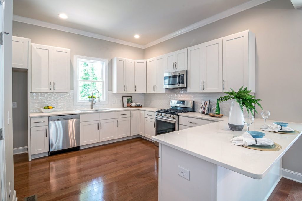 pexels-photo-4682110 Spacious modern kitchen featuring white cabinets and appliances, perfect for home design.